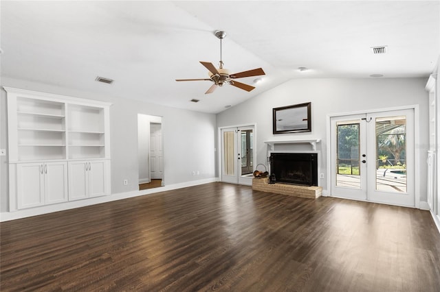 unfurnished living room with french doors, dark hardwood / wood-style flooring, ceiling fan, a fireplace, and lofted ceiling