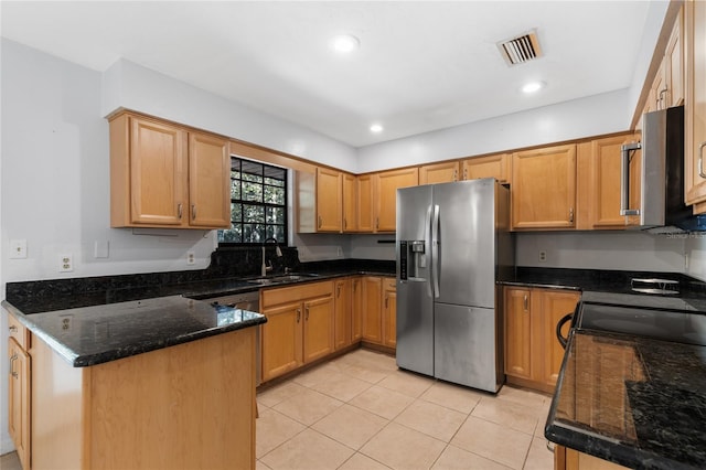 kitchen with kitchen peninsula, stainless steel appliances, sink, light tile patterned floors, and dark stone countertops