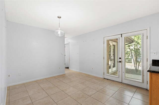 tiled empty room featuring french doors