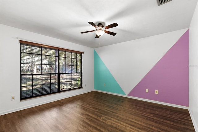 empty room featuring dark hardwood / wood-style flooring and ceiling fan