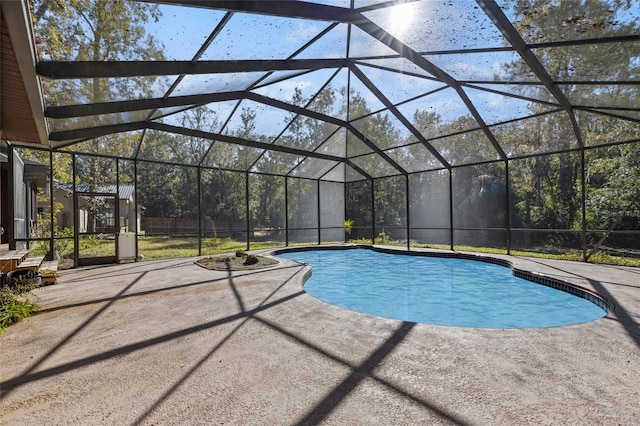 view of pool featuring glass enclosure and a patio area