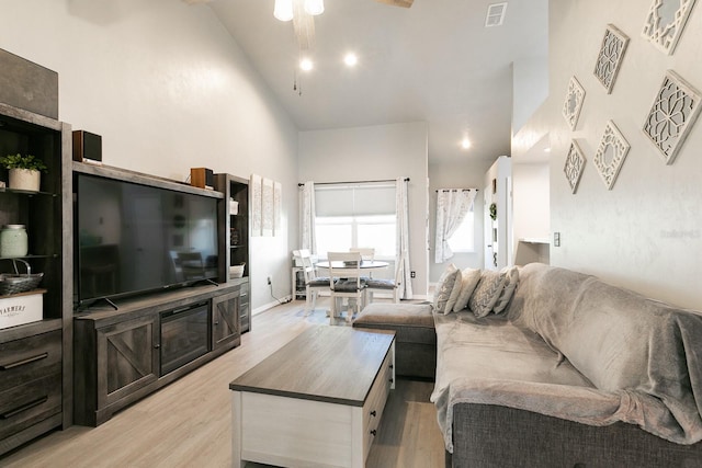 living room with light wood-type flooring, high vaulted ceiling, and ceiling fan