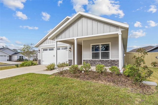 craftsman-style house with covered porch, a garage, and a front lawn