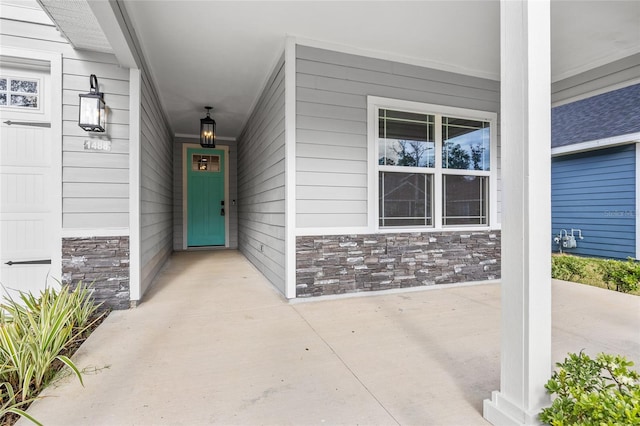 view of exterior entry featuring covered porch