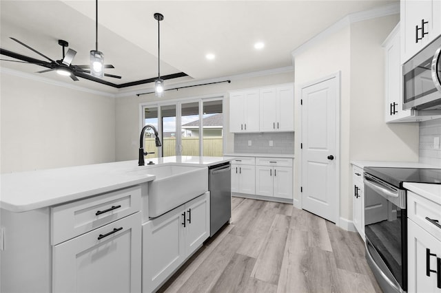 kitchen featuring white cabinets, ceiling fan, appliances with stainless steel finishes, and light hardwood / wood-style flooring