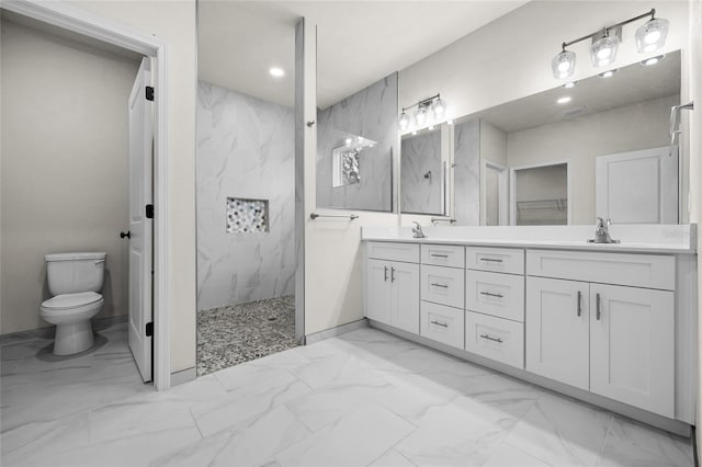 bathroom with tiled shower, vanity, and toilet