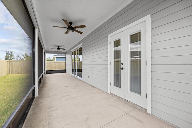 unfurnished sunroom featuring ceiling fan and french doors