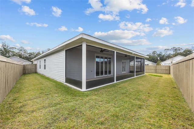 rear view of property with a sunroom, ceiling fan, and a yard