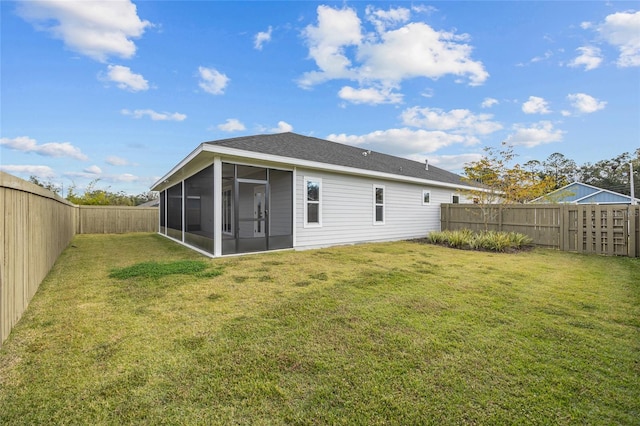 rear view of property featuring a sunroom and a lawn