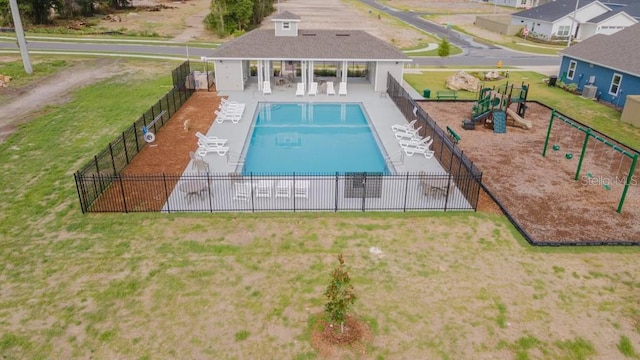 view of pool with a playground, a patio area, and a lawn