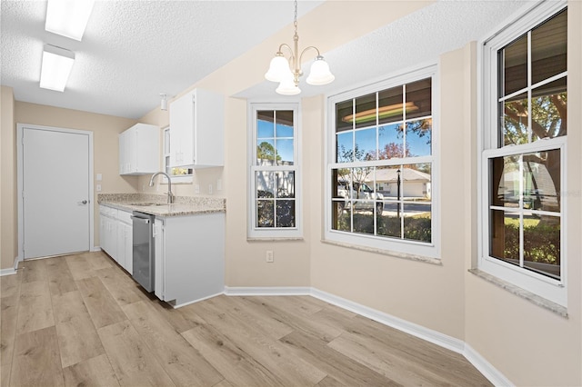 kitchen featuring plenty of natural light, white cabinets, pendant lighting, and light wood-type flooring