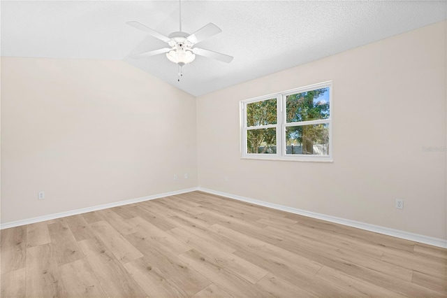 spare room featuring a textured ceiling, ceiling fan, lofted ceiling, and light wood-type flooring