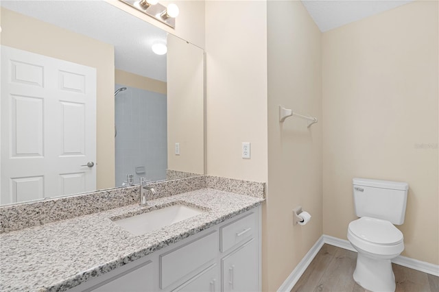 bathroom featuring hardwood / wood-style floors, vanity, a textured ceiling, and toilet