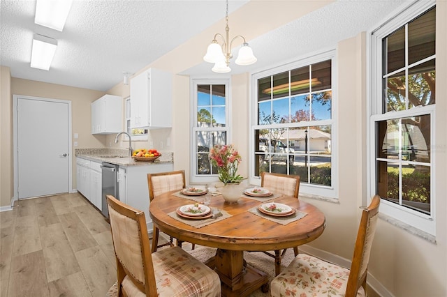 dining area with plenty of natural light, a textured ceiling, and light hardwood / wood-style flooring