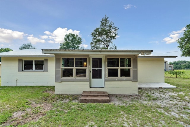 rear view of property featuring a lawn