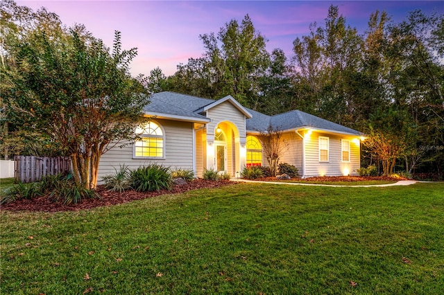 ranch-style home with a yard