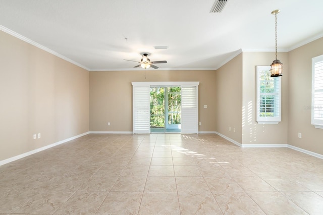 empty room with ornamental molding, a healthy amount of sunlight, visible vents, and baseboards