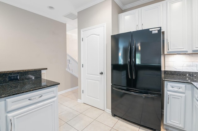 kitchen with white cabinets, black fridge, and dark stone counters