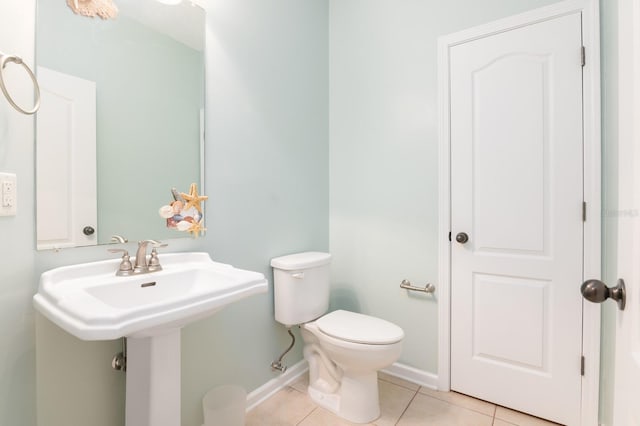 bathroom with toilet, tile patterned floors, and sink