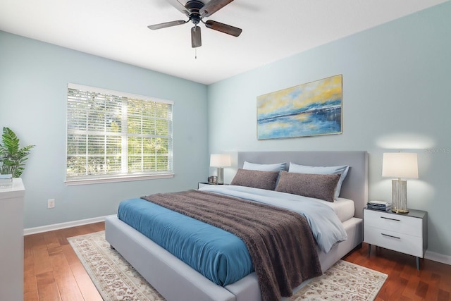 bedroom with dark hardwood / wood-style flooring and ceiling fan