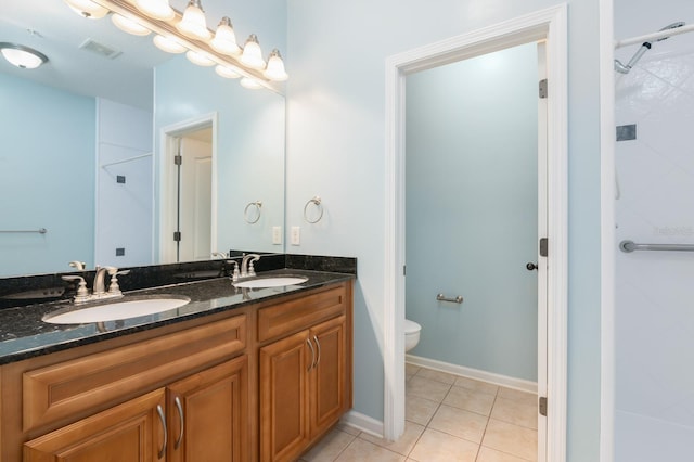 bathroom featuring a shower, tile patterned flooring, vanity, and toilet