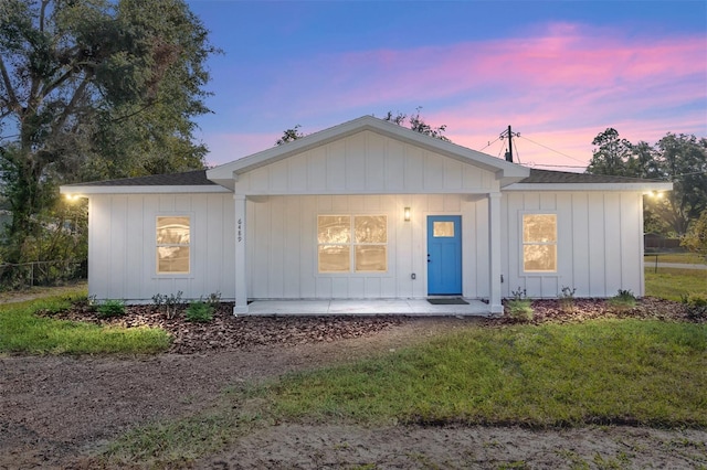 view of front of home with a porch and a lawn