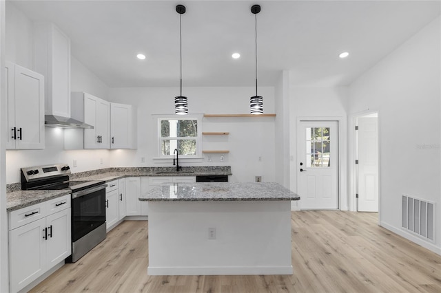 kitchen featuring stainless steel range with electric stovetop, pendant lighting, light hardwood / wood-style flooring, white cabinets, and a center island