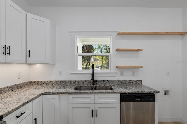 kitchen with dishwasher, light stone counters, white cabinetry, and sink