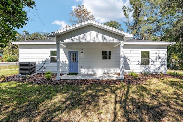 rear view of house with a lawn, cooling unit, and a patio