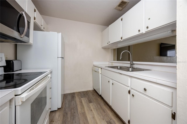 4000 SW 23rd St Unit 5-207, Gainesville, FL 32608 - kitchen featuring white appliances, light wood-style flooring, light countertops, and white cabinetry
