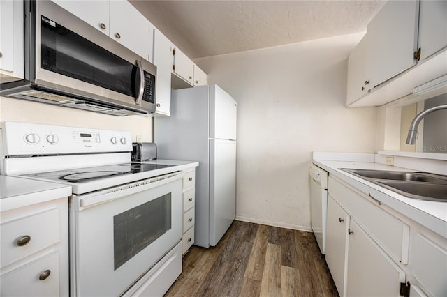 kitchen with dark hardwood / wood-style flooring, white appliances, a textured ceiling, sink, and white cabinets