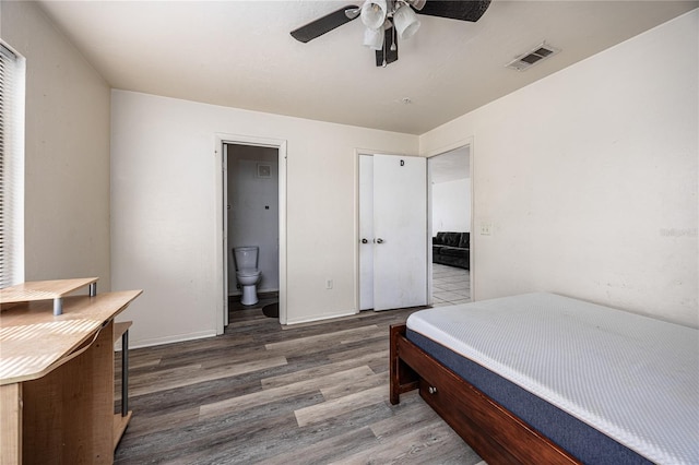 bedroom with dark hardwood / wood-style floors, ensuite bath, and ceiling fan