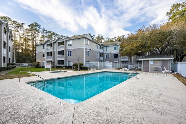 view of swimming pool featuring an outbuilding