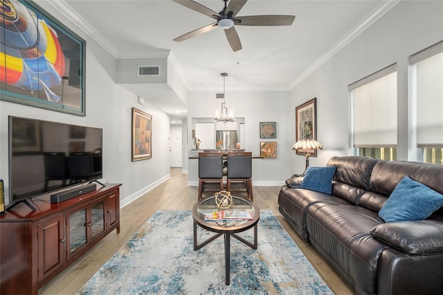 living room featuring ceiling fan with notable chandelier, light hardwood / wood-style floors, and ornamental molding