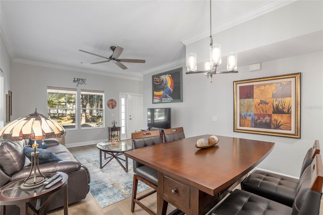 dining space with ornamental molding, ceiling fan with notable chandelier, and hardwood / wood-style flooring