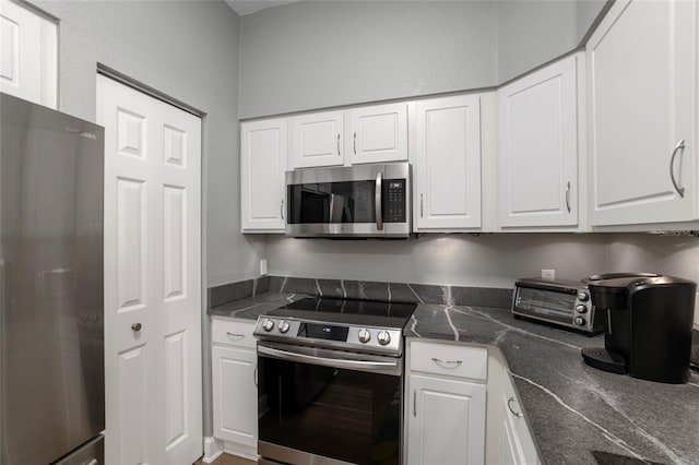 kitchen featuring white cabinets, dark stone countertops, and appliances with stainless steel finishes