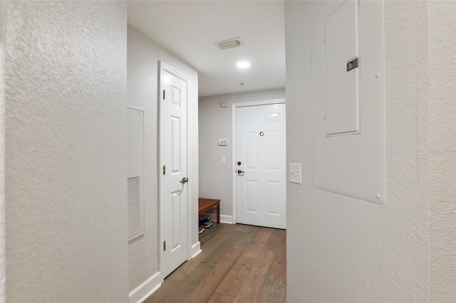 hallway with dark wood-type flooring and electric panel