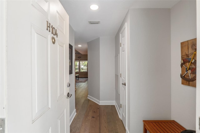 corridor with hardwood / wood-style flooring