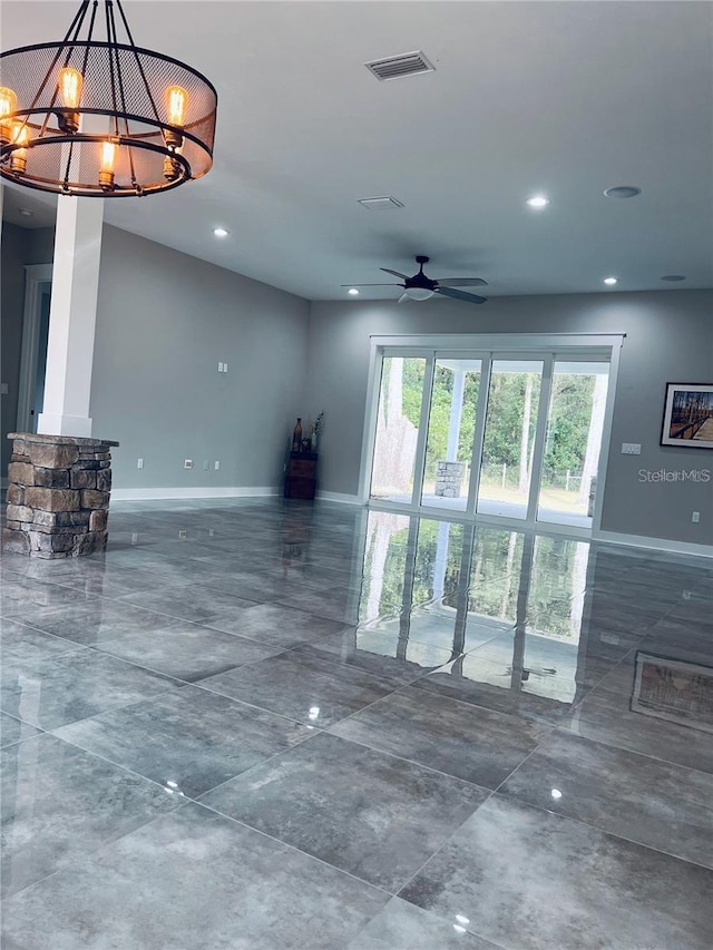 empty room with ceiling fan with notable chandelier