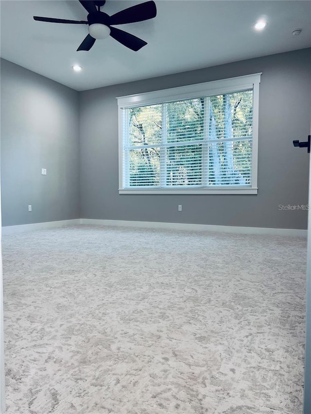 carpeted empty room with plenty of natural light and ceiling fan