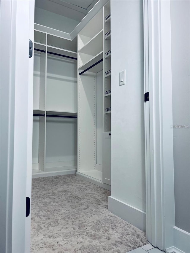 walk in closet featuring light carpet