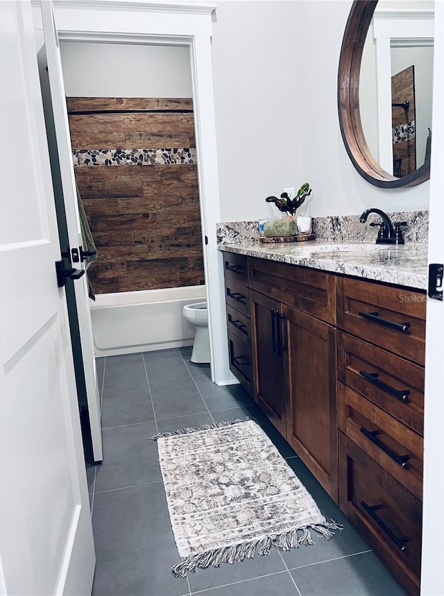 full bathroom featuring vanity, tiled shower / bath, tile patterned floors, and toilet