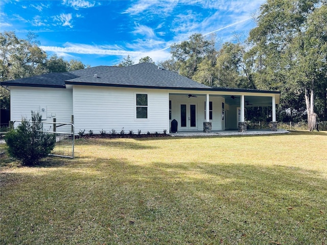 back of property with ceiling fan and a lawn