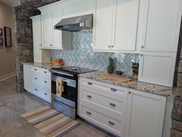 kitchen with stainless steel electric range, backsplash, light stone counters, white cabinets, and wall chimney exhaust hood