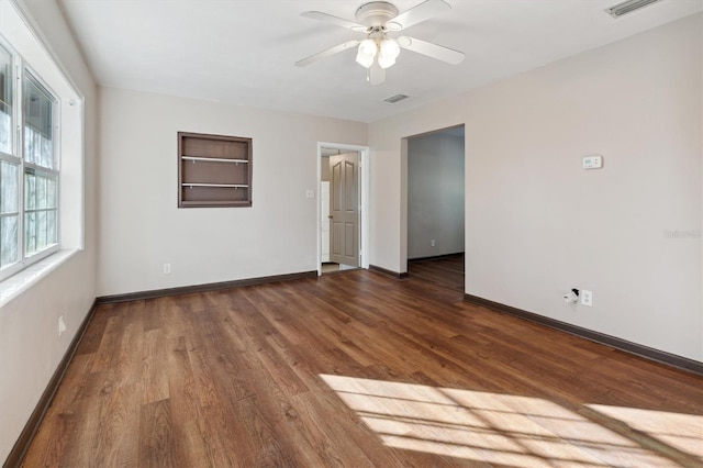 empty room featuring dark hardwood / wood-style flooring and ceiling fan