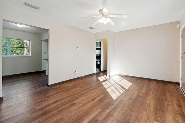 empty room with ceiling fan and dark hardwood / wood-style flooring