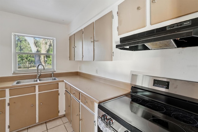 kitchen featuring light tile patterned floors, electric range, and sink