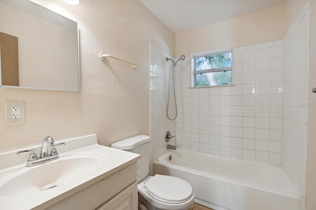 full bathroom featuring tiled shower / bath, vanity, and toilet