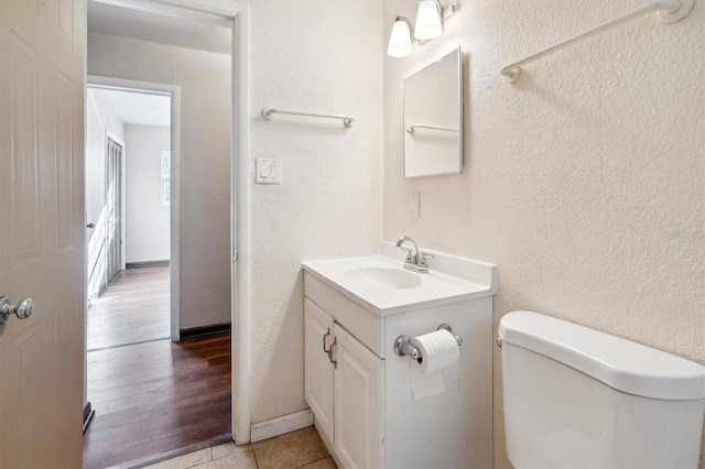 bathroom featuring wood-type flooring, vanity, and toilet