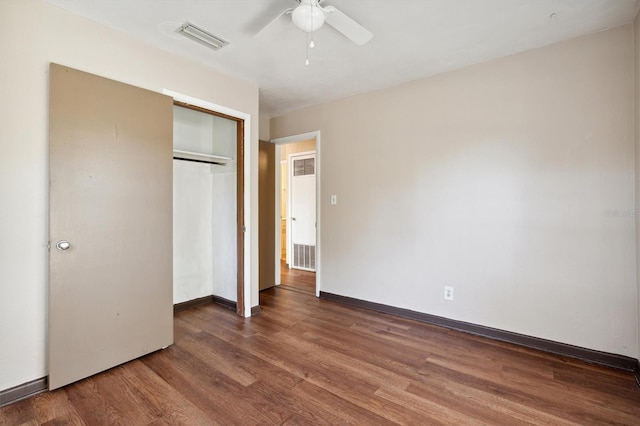 unfurnished bedroom with dark hardwood / wood-style flooring, a closet, and ceiling fan